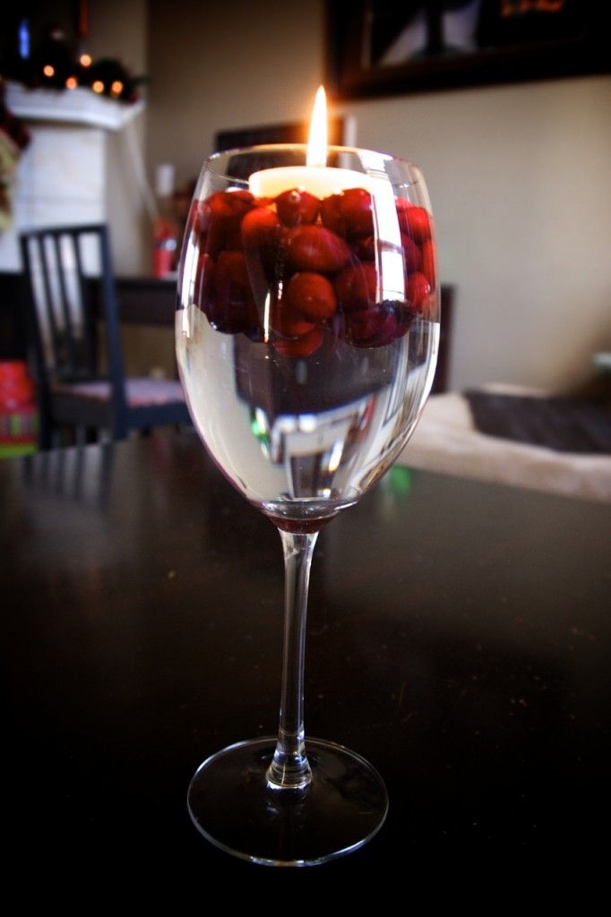 Floating candle in wine glass with water and cranberries