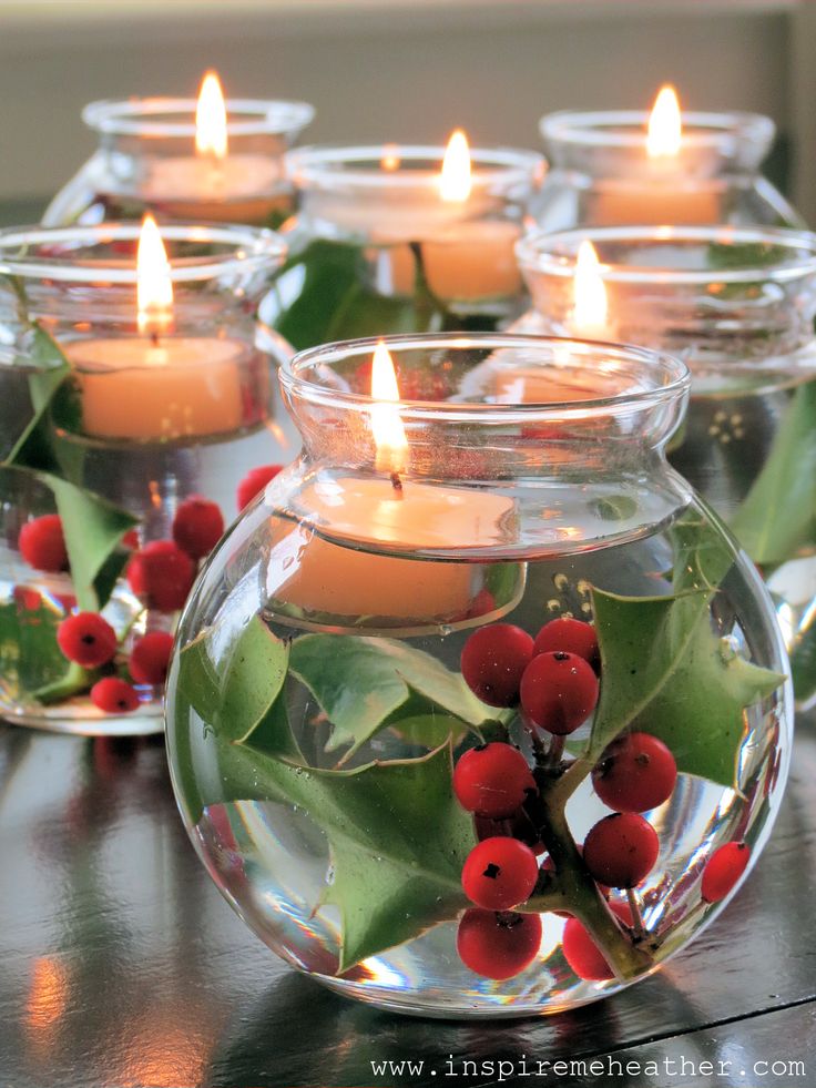 Glass bowls filled with water holly and floating candles