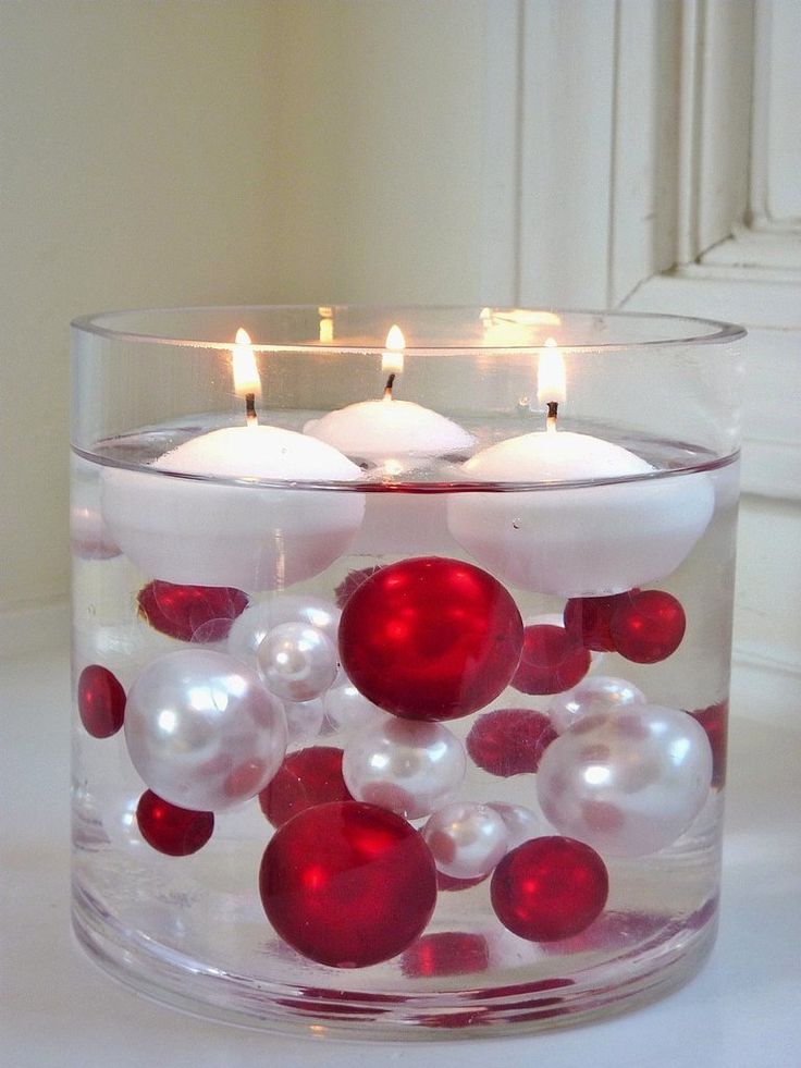 Large glass cylinder with Christmas ball ornaments and floating candles
